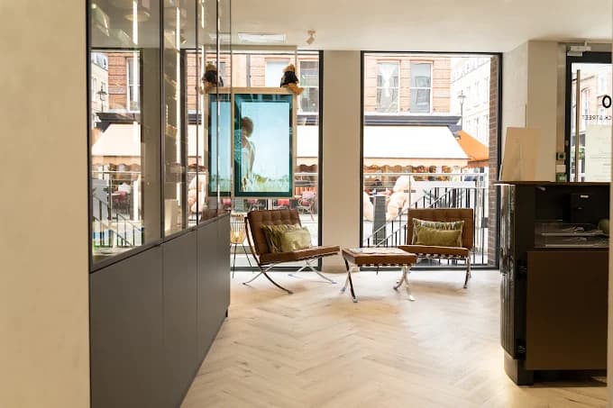 Bright clinic reception with herringbone floor and leather lounge chairs